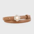 Detailed view of brown leather belt with sparkling rhinestone clover pearl buckle. - Brown