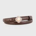 Detail shot of brown leather thin belt with rhinestone pearl clover buckle accessory. - Coffee