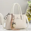 Stijlvolle effen beige schoudertas met elegante strohoed hanger voor dagelijkse mode. - Broken Wit