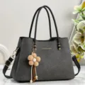 Dark grey textured shoulder handbag detail, elegant black handles and cute flower charm. - Black