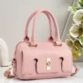 Detailed view of the elegant pink leather handbag featuring a chic metallic lock and handles. - Pink