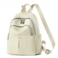 Détail de sac à dos en cuir crème montrant les poches zippées et les bretelles solides. - Blanc Cassé
