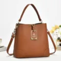 Braune PU Leder Beuteltasche Detailansicht mit Metallbeschlägen und eleganter Textur. - Erdgelb