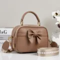 Bruine handtas crossbody tas van leer met schattige strik en gouden metalen details. - camel