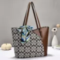 Detailansicht einer stilvollen zweifarbigen Handtasche mit Monogramm Canvas und PU Leder. - Braun