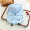 Detail view of the sky blue waterproof hooded pet raincoat, featuring cute pockets and drawstrings. - XS / Sky Blue