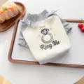 Detailed view of grey and white pet sweater with cute diamond ring embroidery and bows. - XS / Diamond Ring Style