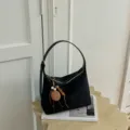 Λεπτομερης οψη της μαυρης πλεκτης τσαντας ωμου με μοναδικο κρεμαστο απο ξυλινες χαντρες. - Με Μενταγιόν / Μαύρο