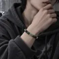 Gros plan détaillé du bracelet de perles élégant avec accent métallique au poignet, look chic. - Bracelet de Perles d'Argent à l'Encre de Suie Sculptée (S0044-A)