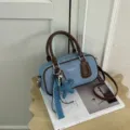 Detailed close-up of blue denim boston handbag with brown leather trim and cute star charm. - With Star Pearl Pendant Style / Coffee
