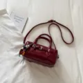 Detail shot of a dark red leather bowling bag with a beaded charm on a white background. - With Pendant / Red