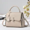 Elegant classic beige leather top handle handbag with adjustable crossbody strap and stylish zippers. - Light Khaki