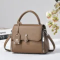 Brown leather top-handle crossbody bag detail, featuring metal zipper and elegant texture. - Dark Khaki
