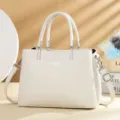 Elegante witte lederen handtas voor dames, stijlvolle schoudertas met handvat en riem. - Wit