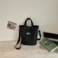 Bolso tote bandolera de lona negra con bolsillo delantero para uso diario casual. - Negro