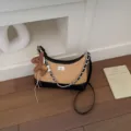 Detailansicht einer Retro-Stroh-Hobo-Umhängetasche mit schwarzem Leder, Kette und Pferdeanhänger. - Mit Anhänger / Schwarz