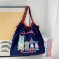 Gedetailleerd overzicht van de donkerblauwe canvas tote bag met schattige geborduurde honden en letters. - Honden Borduurwerk Donkerblauw