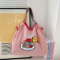 Detailed shot of pink canvas tote bag featuring cute dog and macaron embroidery design. - Heart Dog Pink