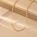Primo piano di una collana di perline sfaccettate champagne scintillante con ciondolo. - Giallo
