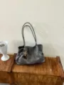 Graue weiche Leder-Tote-Bag für Damen, stilvolle Retro-Umhängetasche mit Quasten. - Mit Anhänger / Grau