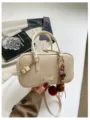 Beigefarbene gewebte Boston Umhängetasche, lässige Kissen-Crossbody-Tasche mit schickem Anhänger. - Mit Anhänger Stil / Weiß