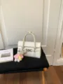 Weisse gewebte Umhaengetasche fuer Damen, elegante schicke PU Leder Handtasche mit Metallverschluss. - Mit Anhänger / Gebrochenes Weiß