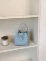 Light blue litchi grain leather bucket bag with metal turn-lock closure for women daily commute. - No Pendant / Blue