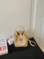 Yellow lychee pattern bucket bag, stylish commuting handbag with shoulder strap and metal lock. - With Charm / Yellow