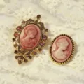 Close-up detail of vintage style cameo brooch with carved female profile and gold frame. - Gold-Pink