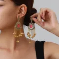 Close-up of ethnic Indian style long tassel bell earrings with pink gemstone and rhinestones. - Center Stone Bell Style (weh6385) / Rose Red Antique Gold