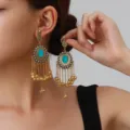 Close-up detail of vintage Indian style long tassel bell earrings with turquoise stone and rhinestones. - Center Stone Bell Style (weh6385) / Light Blue Antique Gold