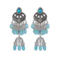 Gros plan de boucles d'oreilles pendantes argentées ethniques vintage avec perles bleues. - Bleu