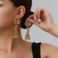 Close-up detail of ethnic vintage golden jhumka earrings with red stone and delicate bell tassels. - Hollow Bell Style (weh6382) / Red Antique Gold