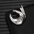 Silver metallic hand gesture brooch detail view, smooth polished alloy fashion accessory. - Hand Shape (X1177-1)