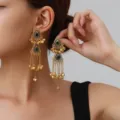 Close-up of vintage ethnic gold-toned long fringe tassel earrings with green stone details. - Exotic Tassel Style (weh6380) / Green Antique Gold
