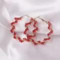 Close-up detail of red crystal beaded hoop earrings with gold-tone twist metal wire design. - Regular Style (ES3657) / Red Rhinestone Embellished