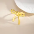 Close-up of a elegant gold alloy bow napkin ring detail, perfect for wedding table decor. - Glossy Bow (X1132-4) / Gold