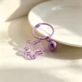 Λεπτομερής όψη του κομψού μωβ DIY κλειδοθήκης με διαφανές αστέρι και μικρό κουδούνι. - Διαφανές Μωβ