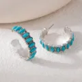 Detailed shot of bohemian vintage silver hoop earrings adorned with vibrant turquoise stones. - Blue