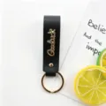 Porte-clés en cuir noir avec lettres métalliques dorées et anneau porte-clés pour cadeaux. - Noir