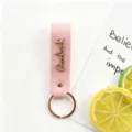 Porte-clés en cuir rose avec pendentif lettre métal Goodluck et anneau en or rose élégant. - Rose