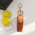Portarossetto in pelle PU marrone portachiavi con accessori dorati, dettaglio ciondolo borsa. - Caffè