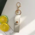 Porte-clés étui à rouge à lèvres en cuir PU avec bouton-pression métallique et pendentif. - Gris