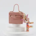 Portachiavi borsa mini in pelle rosa con ciondolo farfalla e lettera F vista principale. - Lettera F