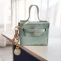 Mintgroene lederen mini handtas sleutelhanger met goudkleurige hardware en parelhangertje. - Blauw