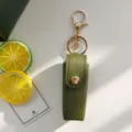 Portachiavi con custodia per rossetto in pelle verde con parti dorate per borsa. - Verde militare