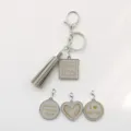 Leren kwast sleutelhanger set met letterhangers, stijlvolle tasaccessoire en perfect cadeau. - Grijs