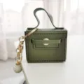 Mini lederen handtas sleutelhanger met parelhangertje, stijlvolle groene tasbedel en accessoire. - Legergroen