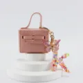 Portachiavi borsa mini in pelle rosa con farfalla e ciondolo con lettera K colorata. - Lettera K
