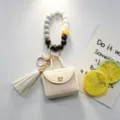 Elegante portachiavi con perline in silicone e mini borsetta portamonete in pelle con nappa - Bianco avorio